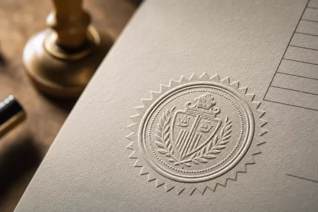 Macro d’un sceau officiel en relief pressé sur du papier épais, évoquant la conformité de la facture électronique et la checklist ERP champ par champ.