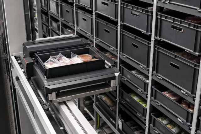 Close architectural view of an automated shuttle warehouse system with repeated totes representing lot-controlled food inventory for FSMA 204 traceability.