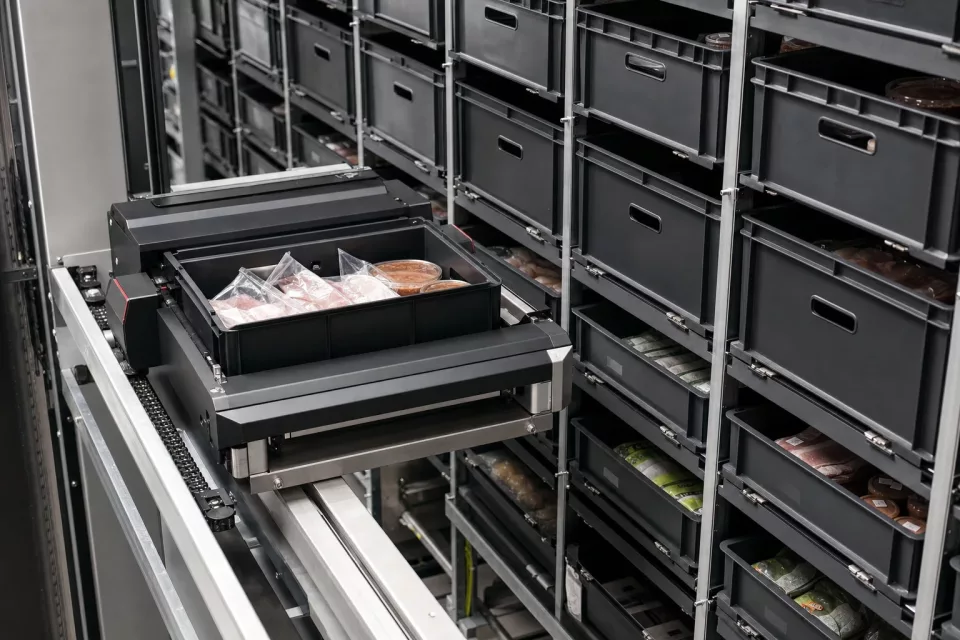 Close architectural view of an automated shuttle warehouse system with repeated totes representing lot-controlled food inventory for FSMA 204 traceability.